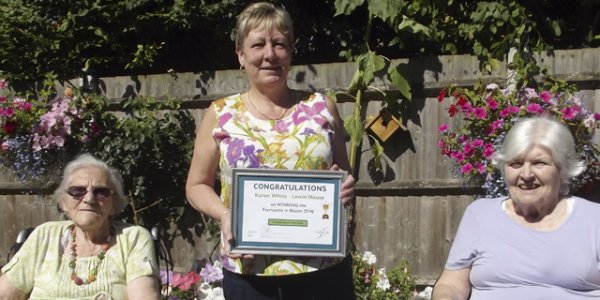 Karen White winner of Gardener of the Year, Fremantle in Bloom, holding her certificate between two female residents