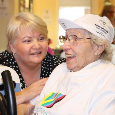Two ladies chatting whilst one is on an exercise bike
